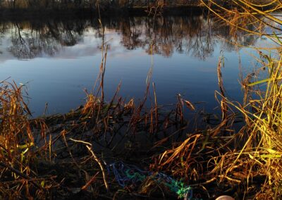 Filet de pêche et bouées en céramique sur berge de rivière