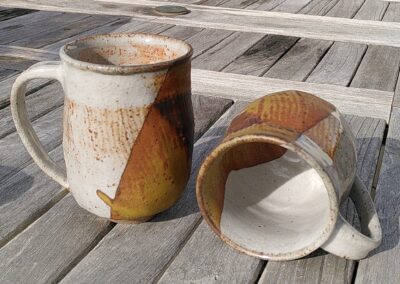 2 mugs en céramique sur une table en bois.