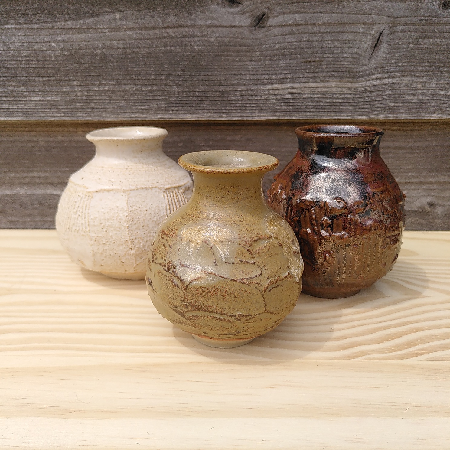 3 petits vases à boutons bulbeux et facettés. Un blanc, un rouge et un ocre.