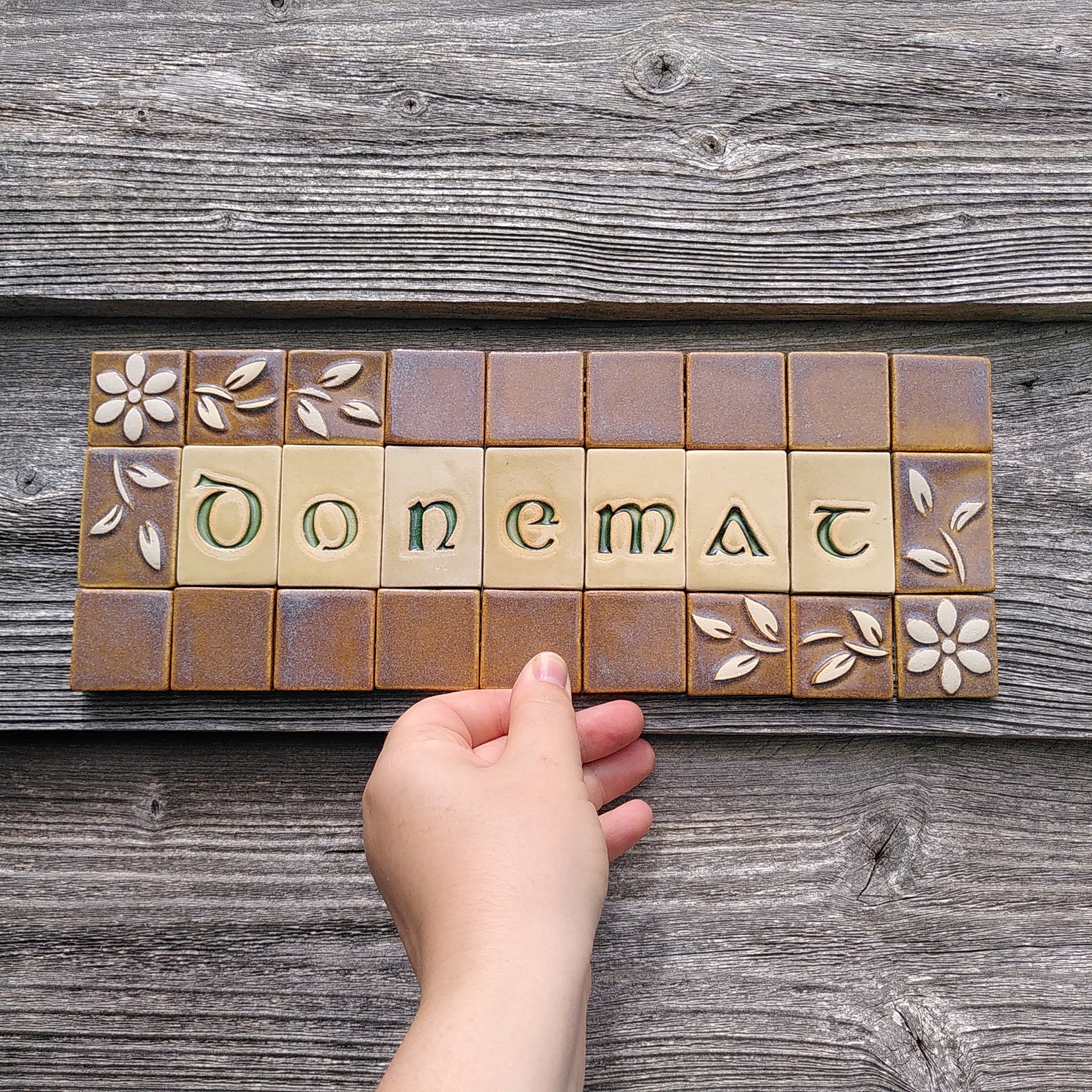 Une plaque en mosaïque en céramique sur laquelle il est écrit "Donemat" qui veut dire Bienvenue en breton